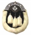 The sporran is made of black and white rabbit fur with a silver chrome thistle mounted on the front and 3 white fur tassles dangling on chains.