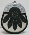 The SPORRAN is black leather with a Celtic cantle, a white cowhide base on the front overlayed with leather detailing and studs.